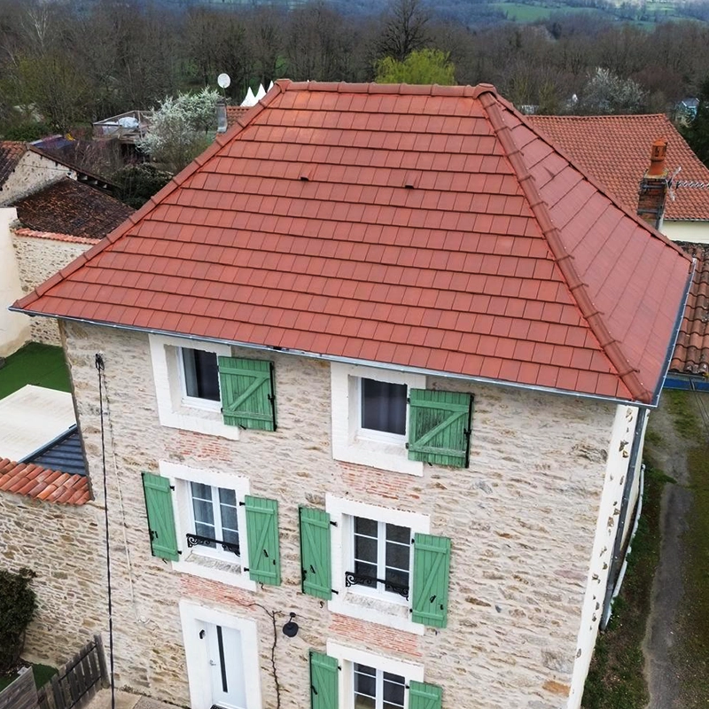 Travaux de couverture sur une grande maison avec un toît en tuile