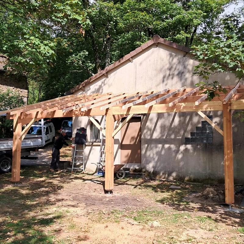 Fabrication d'un abri avec une charpente en bois extérieure, collée à une maison