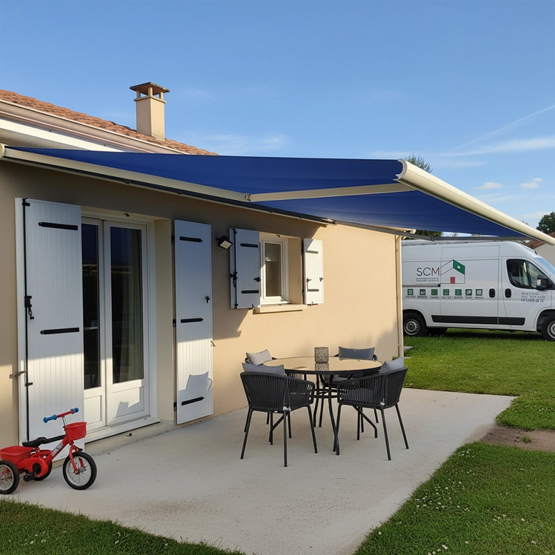 Une terrasse avec une table et des chaises noires, et un store banne bleu à ouverture motorisée